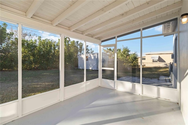 unfurnished sunroom with vaulted ceiling with beams