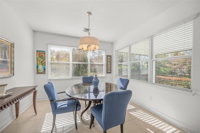 tiled dining space with an inviting chandelier