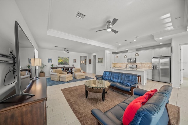 living room featuring light tile patterned floors, a raised ceiling, and ceiling fan