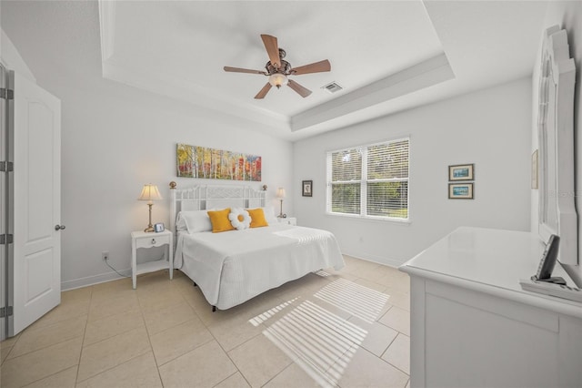 tiled bedroom with a tray ceiling and ceiling fan