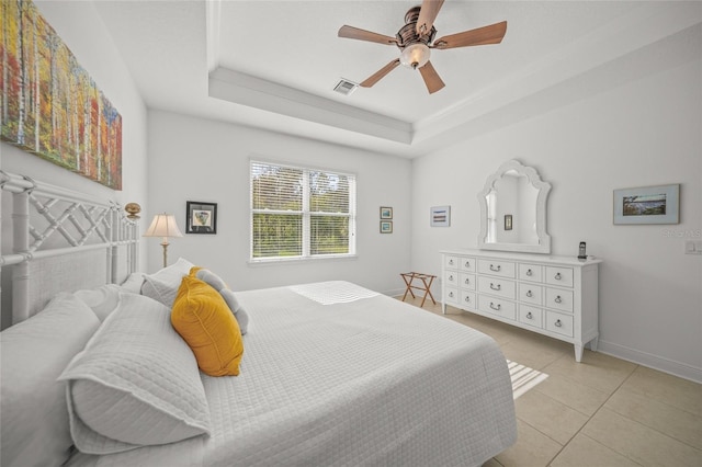 tiled bedroom featuring ceiling fan and a raised ceiling