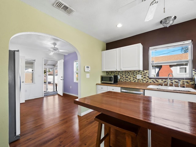 kitchen featuring ceiling fan, sink, dark hardwood / wood-style flooring, white cabinets, and appliances with stainless steel finishes