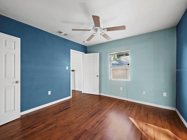 unfurnished bedroom with a textured ceiling, ceiling fan, and dark hardwood / wood-style floors