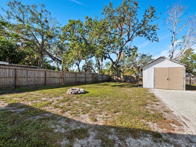 view of yard with a fire pit and a storage shed