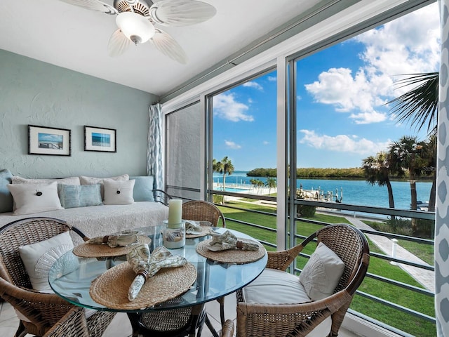 sunroom with ceiling fan, a water view, and a wealth of natural light