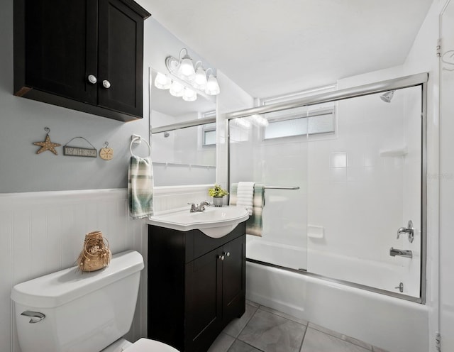 full bathroom featuring tile patterned flooring, vanity, toilet, and bath / shower combo with glass door