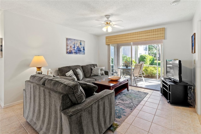 living room with ceiling fan, light tile patterned floors, and a textured ceiling