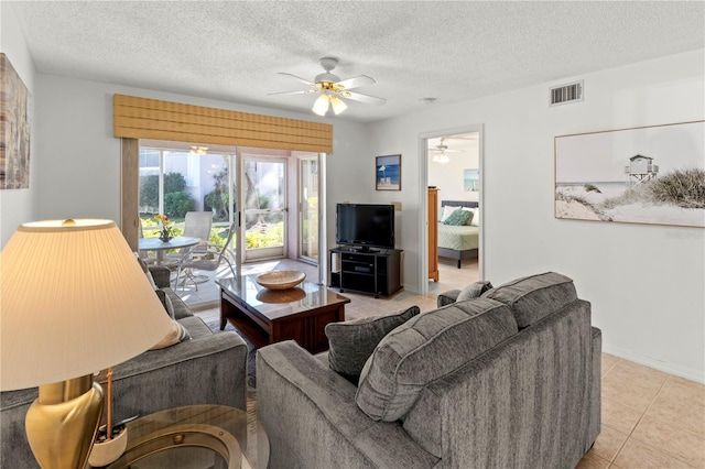 living room featuring light tile patterned floors, a textured ceiling, and ceiling fan