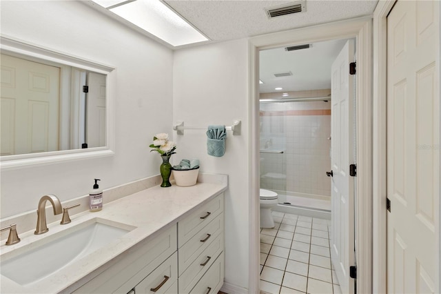 bathroom with tile patterned flooring, vanity, toilet, and walk in shower