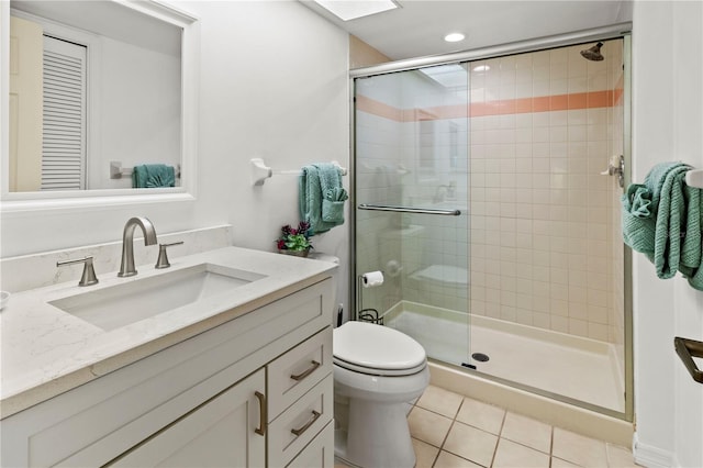 bathroom with tile patterned floors, vanity, an enclosed shower, and toilet