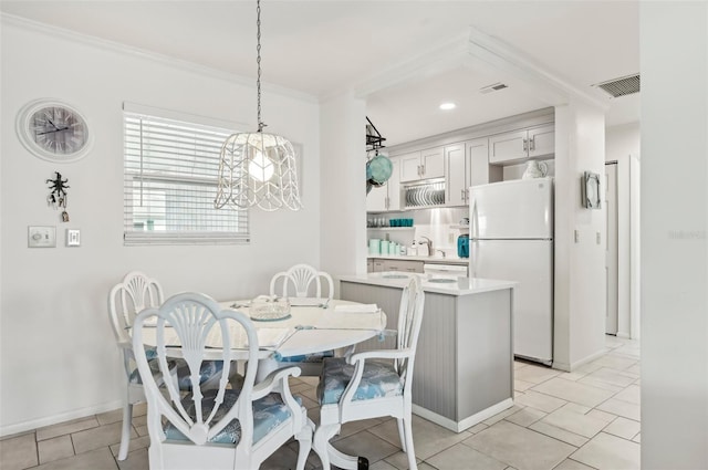 dining area featuring light tile patterned flooring, crown molding, and a notable chandelier