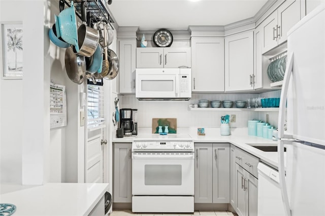 kitchen featuring gray cabinetry, decorative backsplash, sink, and white appliances