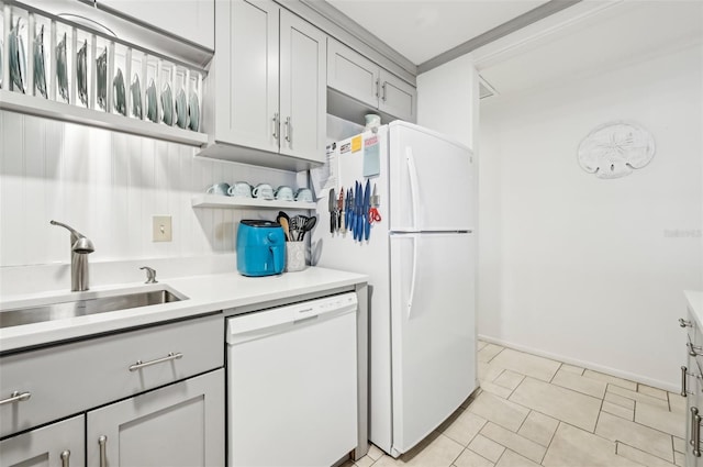 kitchen with gray cabinetry, sink, light tile patterned floors, and white appliances