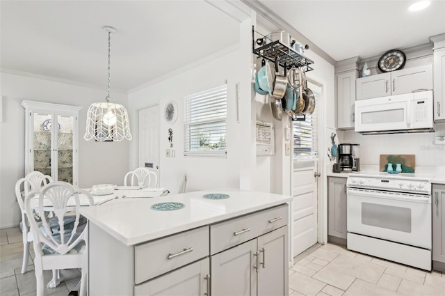 kitchen with a breakfast bar, pendant lighting, white appliances, and ornamental molding