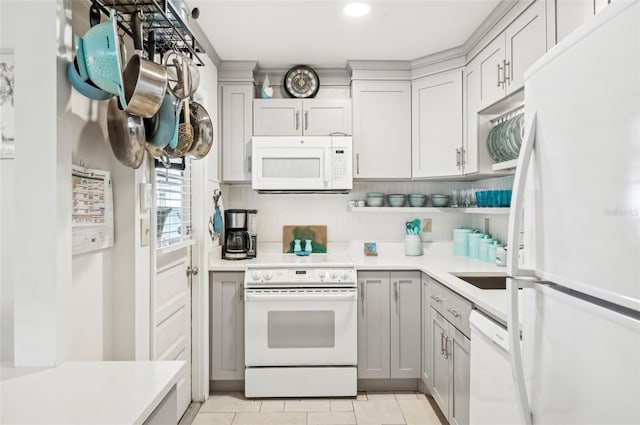 kitchen with gray cabinets, light tile patterned flooring, and white appliances