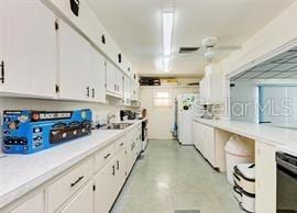 kitchen featuring white cabinetry, sink, ceiling fan, and range