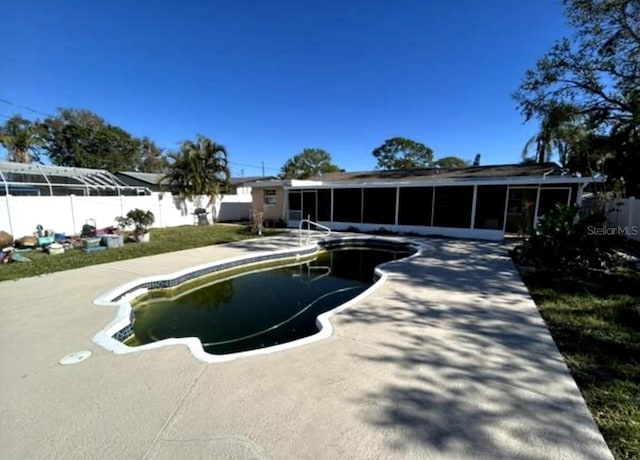 view of swimming pool featuring a sunroom