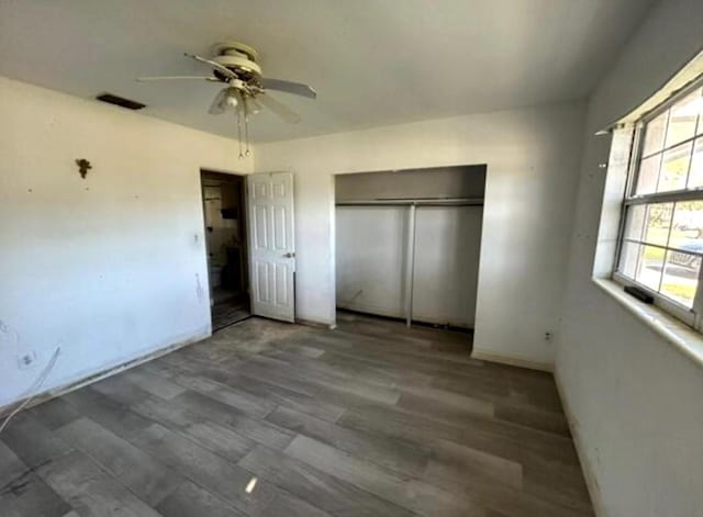 unfurnished bedroom with wood-type flooring, a closet, and ceiling fan