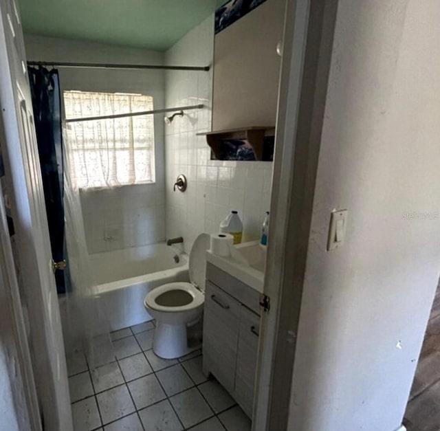 full bathroom with tile patterned floors, shower / bath combo with shower curtain, vanity, and toilet