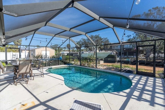 view of pool with a patio area and glass enclosure