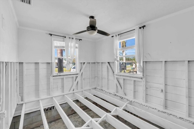 interior space with ceiling fan and ornamental molding