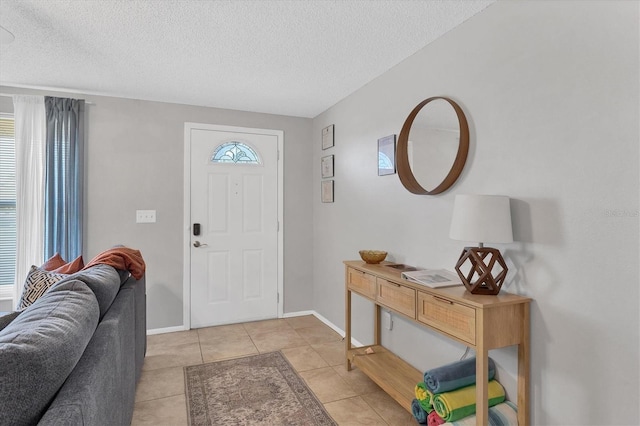 foyer featuring light tile patterned flooring and a textured ceiling