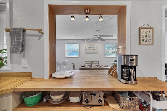 dining space featuring a textured ceiling, track lighting, and ceiling fan