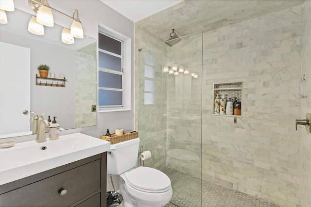 bathroom featuring tiled shower, vanity, and toilet