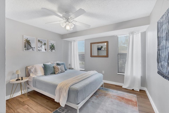 bedroom featuring ceiling fan, a textured ceiling, and light wood-type flooring