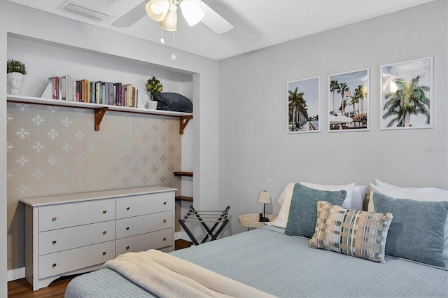 bedroom featuring wood-type flooring, a textured ceiling, and ceiling fan