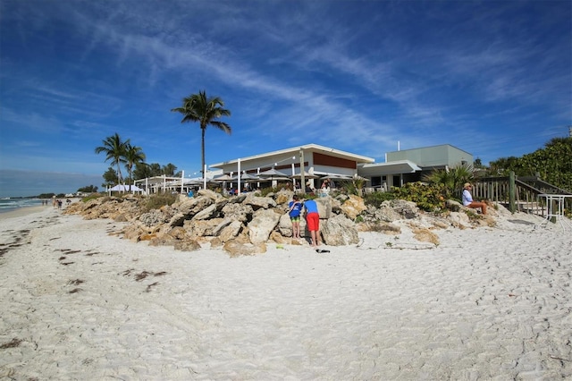 view of yard featuring a water view and a beach view