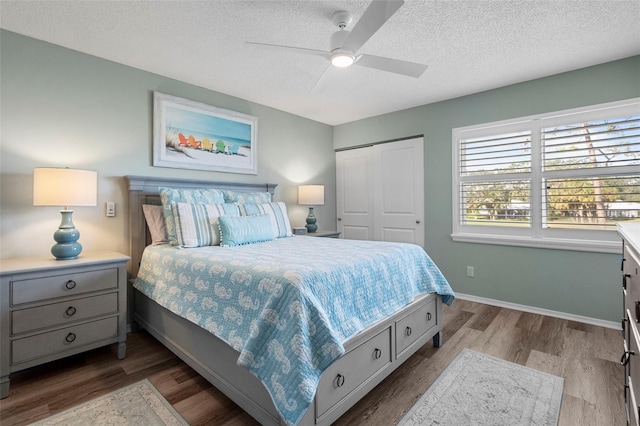 bedroom with ceiling fan, a closet, hardwood / wood-style floors, and a textured ceiling