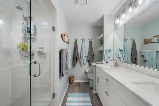 bathroom featuring toilet, vanity, wood-type flooring, and walk in shower