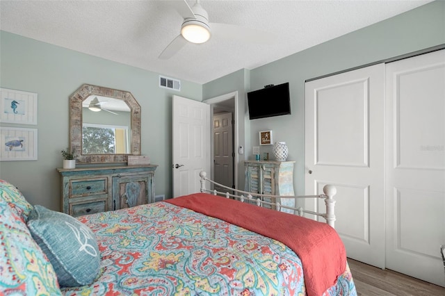 bedroom featuring ceiling fan, a closet, a textured ceiling, and hardwood / wood-style flooring