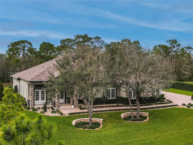 view of front of home featuring a front yard and french doors