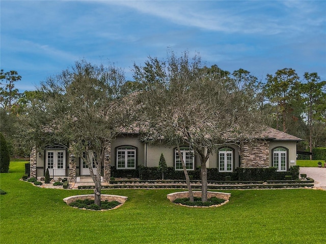 view of front of house with french doors and a front lawn