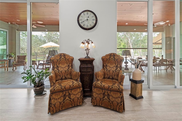 living area with ceiling fan and wood ceiling