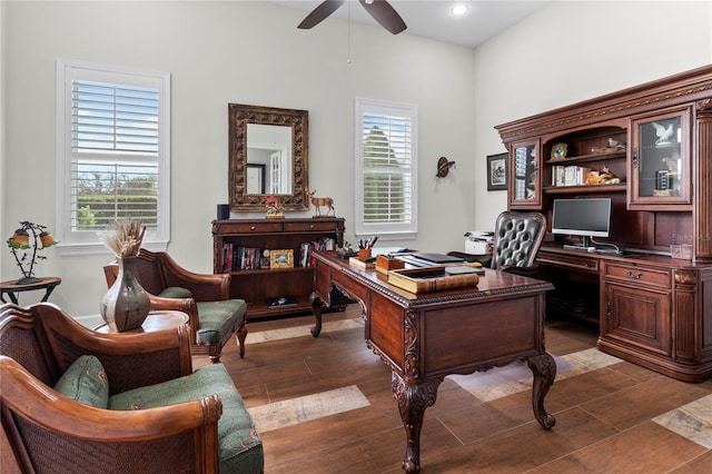 office space featuring dark hardwood / wood-style flooring, ceiling fan, and a healthy amount of sunlight