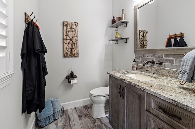 bathroom with hardwood / wood-style floors, vanity, toilet, and backsplash