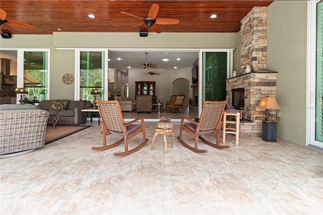 view of patio / terrace featuring an outdoor living space with a fireplace and ceiling fan