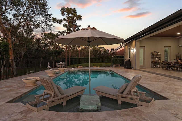 pool at dusk with a patio