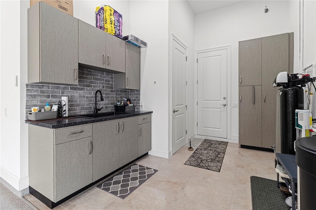 kitchen featuring tasteful backsplash, gray cabinetry, sink, and light tile patterned flooring