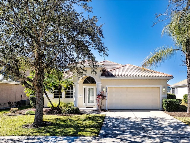 mediterranean / spanish-style house with a front yard and a garage