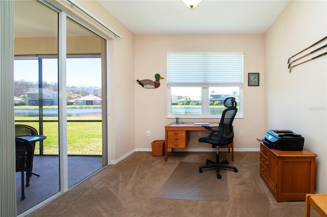 office space featuring light carpet and a water view