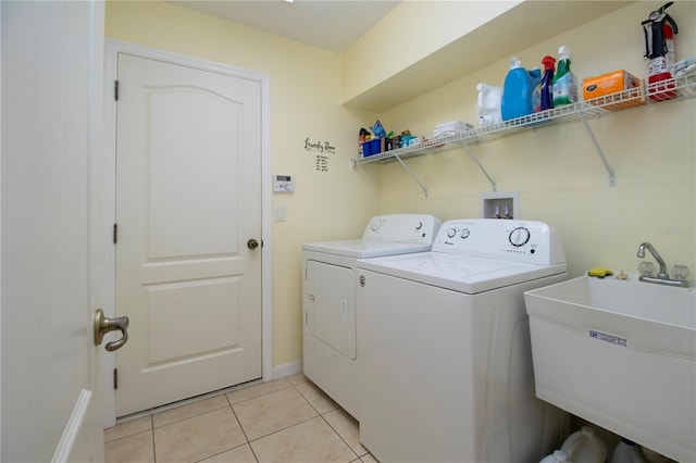 washroom featuring washer and dryer, light tile patterned floors, and sink