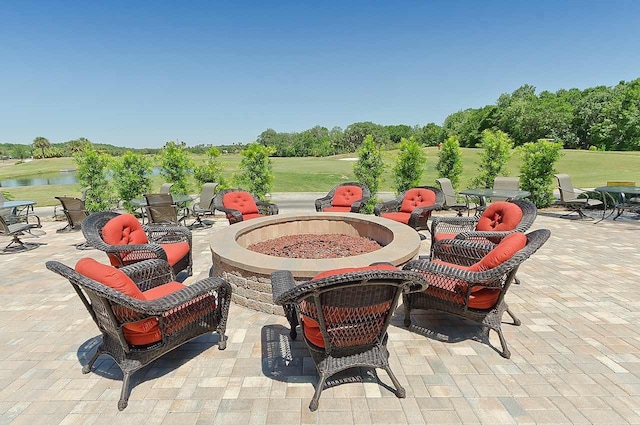 view of patio with a fire pit and a water view