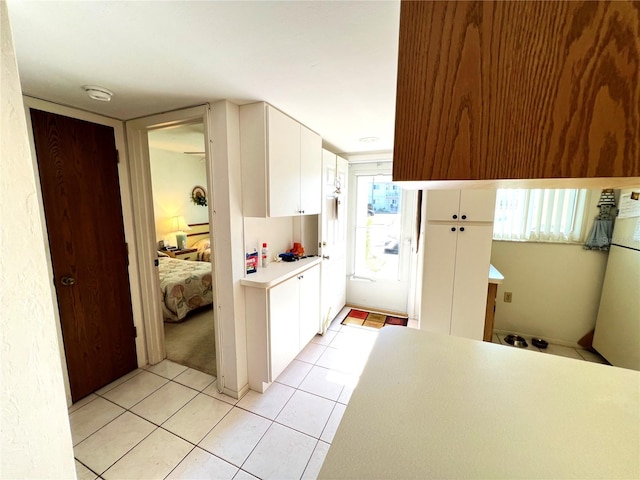 kitchen with white cabinets, light tile patterned flooring, and a wealth of natural light