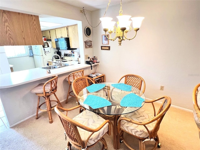 dining area featuring light colored carpet, an inviting chandelier, and sink