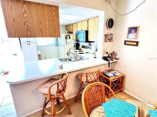 kitchen featuring kitchen peninsula, white appliances, and sink