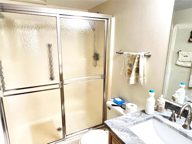 bathroom with vanity, toilet, and a shower with shower door